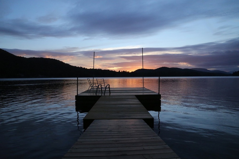 The new house has a dock and incredible views of sunset over the water.